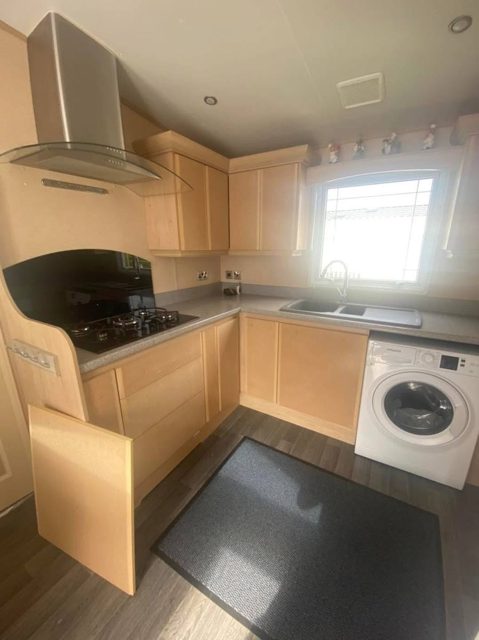 Caravan kitchen with dated pine-effect units, before